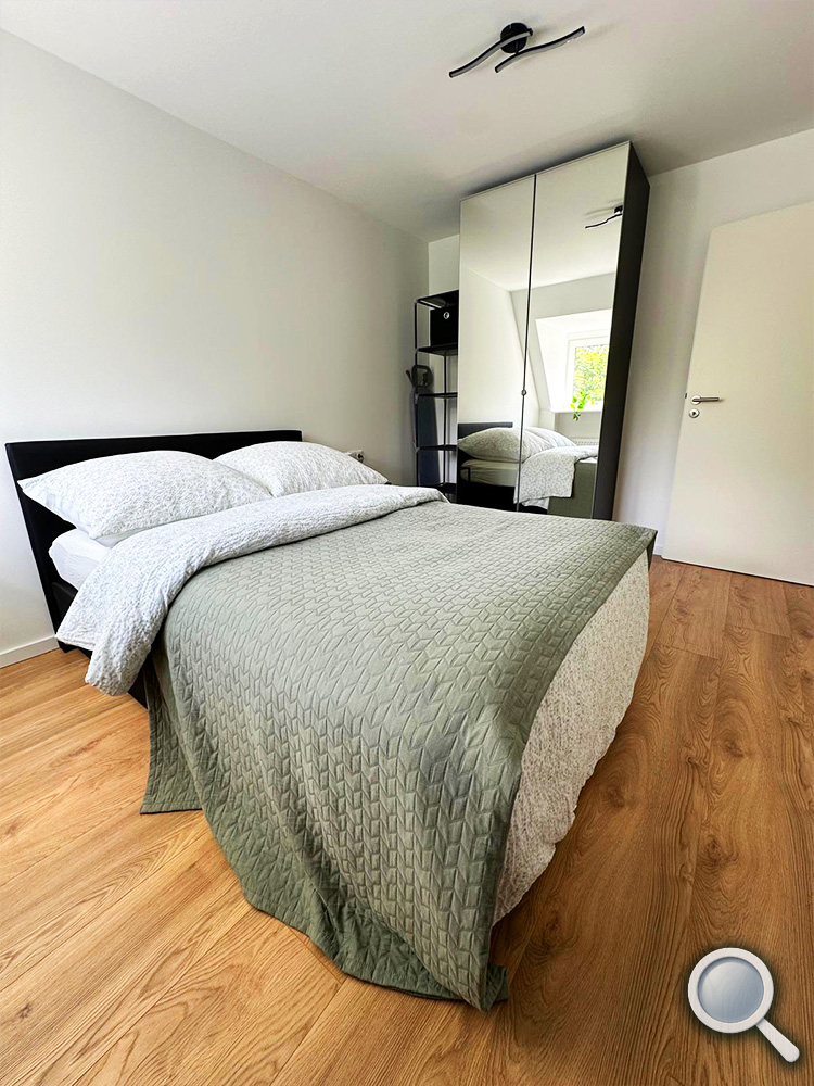 Schlafzimmer mit Doppelbett und Kleiderschrank in der Ferienwohnung