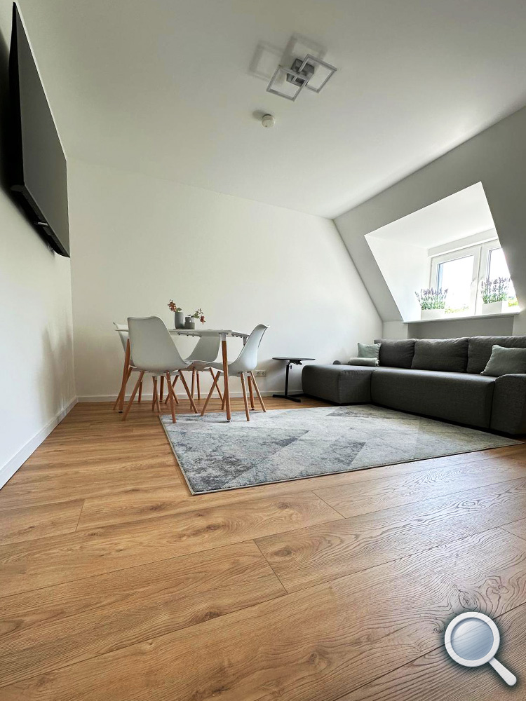 Helles Wohnzimmer mit Schlafsofa und Esstisch in der Ferienwohnung
