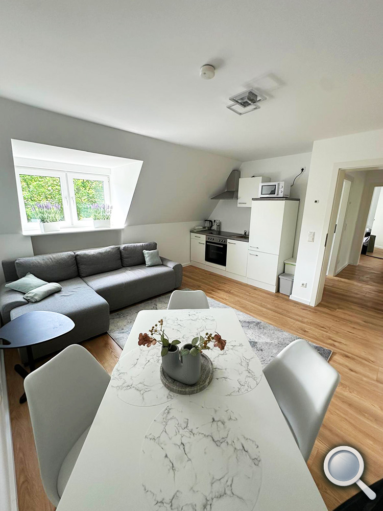 Wohnzimmer der Ferienwohnung in Hilchenbach-Allenbach mit Sofa, Esstisch und Küche
