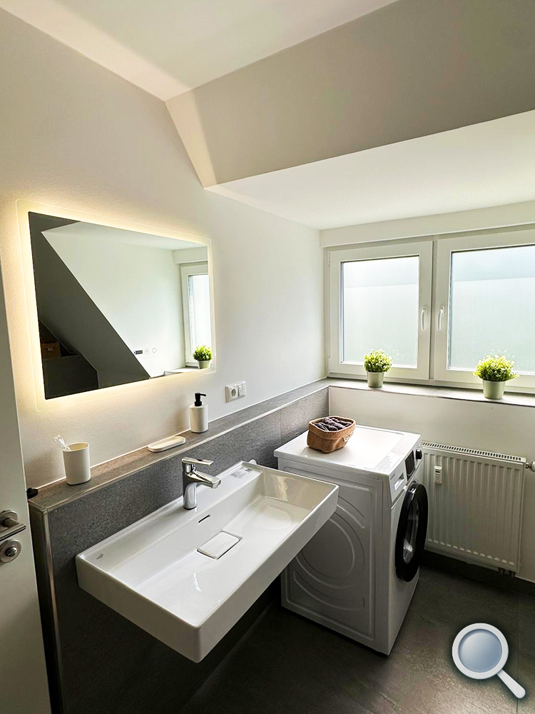 Modernes Badezimmer mit Waschbecken und Waschmaschine
